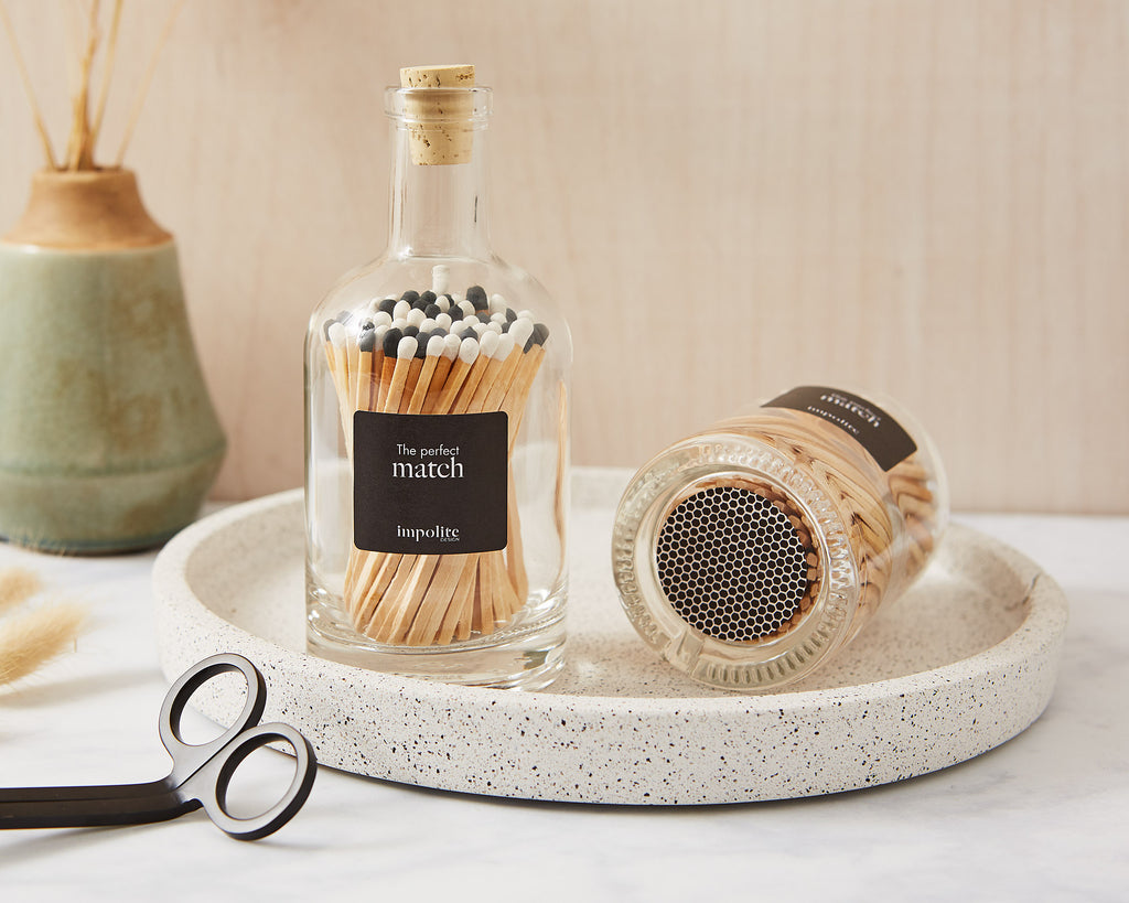 Stylish glass bottle of coloured matches with strike pad on the bottom for candles